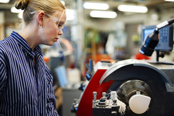 En student arbetar i en metallverkstad.