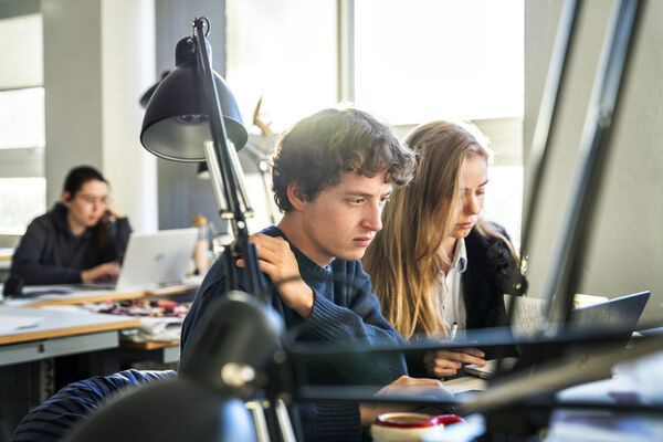 Två studenter arbetar vid en dator.